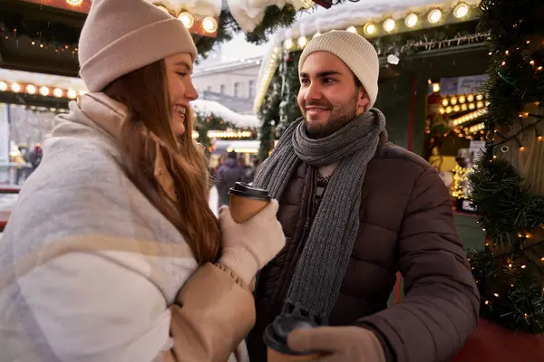 Kaukasisches Paar Trinkt Glühwein Und Plaudert Auf Weihnachtsmarkt Stockfoto