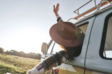 Kamp arabasından sarkan Kadın Manzaranın tadını çıkarıyor