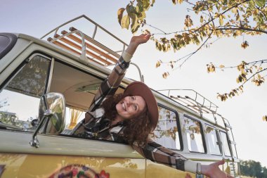 Kamp arabasının camından sarkan kadın gün batımında