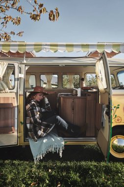 Çimenlerde Kamp Minibüsünün Yanında Oturan Kadın