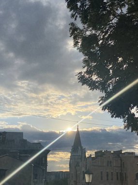 Güneş şehrin arka planında.