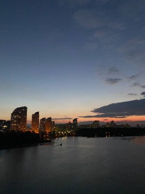 Gölün kıyısında güzel bir gün batımı şehrin arka planında ördekler