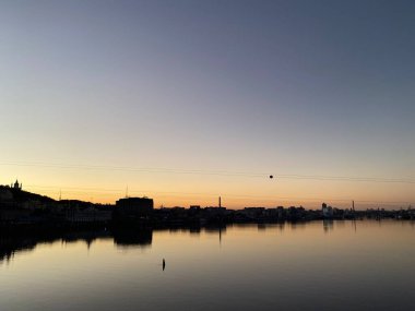 Şehir siluetiyle Dnipro Nehri 'nde güzel bir gün batımı.