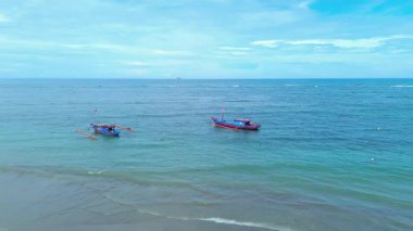 Endonezya sahilinin doğal manzarası, açık bir sabahta beyaz kum ve mavi deniz.