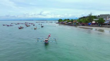Endonezya sahilinin doğal manzarası, açık bir sabahta beyaz kum ve mavi deniz.