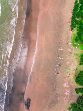 Endonezya sahilinin doğal manzarası, açık bir sabahta beyaz kum ve mavi deniz.