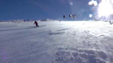 Slovakya, Jasna - 7 Şubat 2019: kar fırtınası. Mavi gökyüzündeki güneş. Birkaç kayakçı ve bir snowboardcu. Yavaş çekim