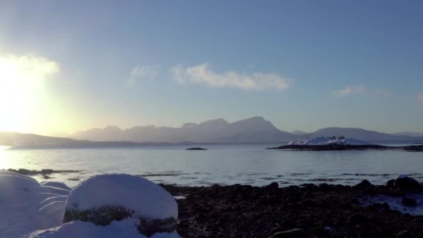 ノルウェーだ 冬の日にロフテン島 明るい太陽と雪の間のフィヨルドの上に驚くべき雲帽をかぶった山々 パノラマ — ストック動画