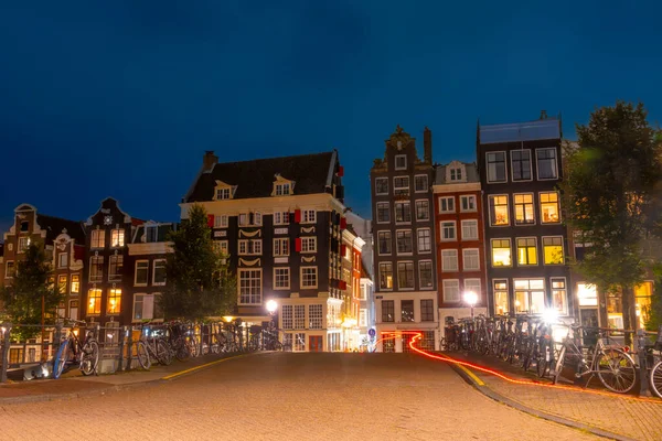 네덜란드 암스테르담에서의 다리의 울타리에 자전거 가운하와 부두에 전형적 네덜란드 건물에 — 스톡 사진