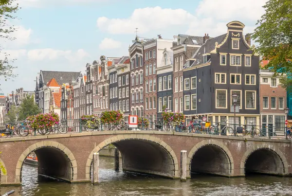 Nizozemsko Starý Kamenný Most Amsterodamském Kanálu Typické Holandské Domy Tančícími — Stock fotografie