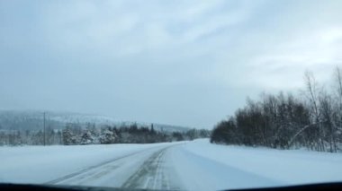 Fin Laponyası. Kış ormanı yolunda araba sürüyorum. Dağlık arazide karla kaplı ağaçlar