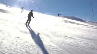 Jasna kayak merkezindeki Slovak Tatras 'ta güneşli bir kış günü. Kar fırtınası. Bir kayakçı kayak pistinde bir dönüş yapar. Yavaş çekim
