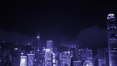 Gece Hong Kong. Bir pilot gemisi Victoria Limanı boyunca gökdelen ışıklarının arka planına doğru yol alır.