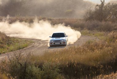 Güneşli bir yaz günü. Tozlu rali pisti. Bir rali arabası 28 dönüşte çok toz yapar.