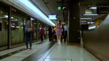 Hong Kong - 1 Mayıs 2016: Metro istasyonunun yeraltı bölümü. Kalabalık yolcular vagonlara girip çıkıyorlar ve hareket halindeki merdivenleri çıkıyorlar. Hızlı hareket