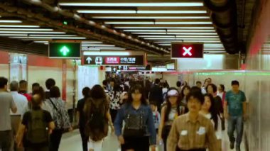 Hong Kong - 1 Mayıs 2016: Metro istasyonunda yeraltı yaya geçidi. Erkek, kadın ve çocuk kalabalıkları her iki yöne de hareket ediyor. Hızlı hareket
