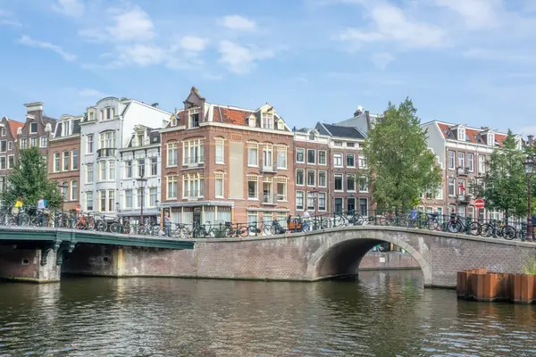 Niederlande Sommertag Typische Holländische Häuser Der Uferpromenade Von Amsterdam Steinbrücken lizenzfreie Stockbilder