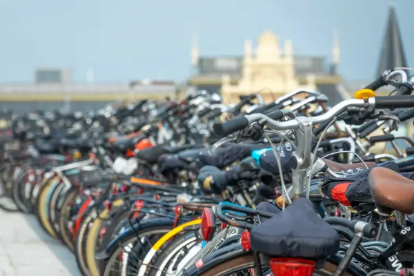 许多自行车停在阿姆斯特丹中央车站附近一个简陋的立面后面的自行车停车场里 免版税图库照片
