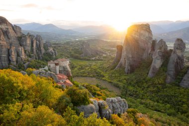 Yunanistan. Kayadaki manastır. Günbatımı ışınları yeşil Meteora vadisinde