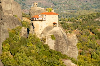 Yunanistan. Kalambaka Vadisi 'nde güneşli bir yaz günü. Uçurumun tepesindeki manastır ve yeşil vadi.