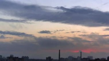 Gün doğumu bulutları deniz kenti üzerinde hızla hareket eder. Güneşin batış ışınları. Zaman aşımı