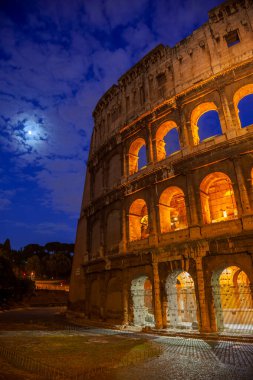 İtalya. Roma 'da ay ışığı altında bir yaz gecesi. Colosseum gece aydınlandı.
