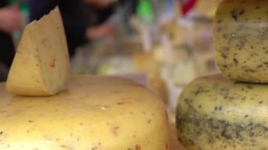 Hollanda 'da. Amsterdam 'da çiftçi pazarı. Pek çok peynir ve müşteri tipleri bulanık. Ön planda peynir kafalar var. Yavaş çekim