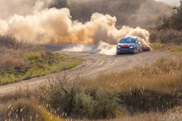 Bozkırlarda güneşli bir yaz günü. Toprak bir virajda yarış arabası ve gün ışığında toz bulutu.