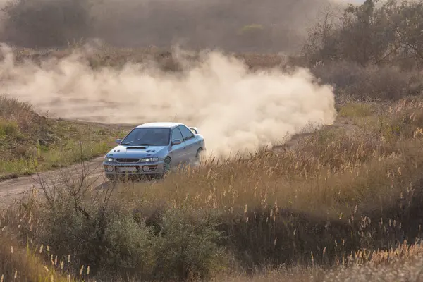 Bozkırlarda güneşli bir yaz günü. Keskin bir toprak virajda spor araba ve toz bulutu