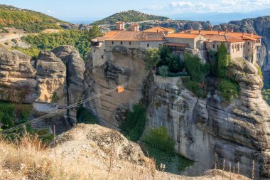 Kuzey Yunanistan. Meteora 'da güneşli bir yaz günü. Uçurumun tepesindeki manastır ve keşişler için teleferik.