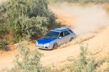 Bozkırlarda güneşli bir yaz günü. Tozlu bir spor hatchback toprak bir yoldan çıkıyor.