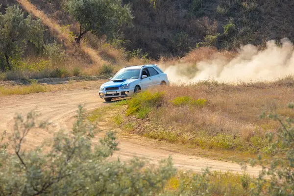 Bozkırlarda güneşli bir yaz günü. Bir spor hatchback toprak yolda bir tur atar