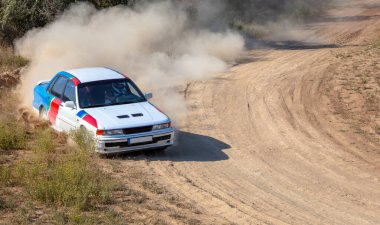 Bozkırlarda güneşli bir yaz günü. Toprak bir yolda keskin bir virajda spor araba ve toz bulutu