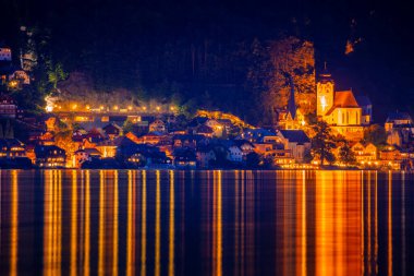 Avusturya yazı. Hallstatt kasabasının gece ışıkları ve suyun ayna yüzeyinde yansıma.