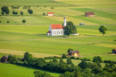 Yaz Almanya. Bavyera ovasında güneşli bir gün ve yeşil tarlalarla çevrili bir kilise.