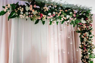 Çiçek ve yeşillik kompozisyonu ile süslenmiş yeni evliler, düğün salonundaki mumlar. Çadırda düğün partisi.