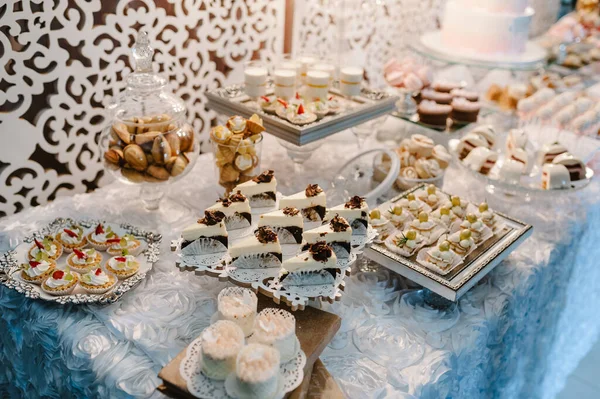 Kek, kek, şeker, şeker, açık büfe. Düğün ziyafeti alanı için tatlı masası. Kapatın. Çikolata. Madalyalı lezzetli..