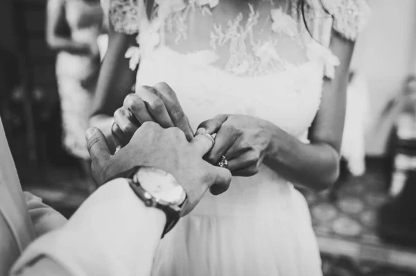 花嫁の手は新郎の指に婚約指輪をつけています 結婚式の日 ウェディングリング付きの手 閉めろ 白黒写真 — ストック写真