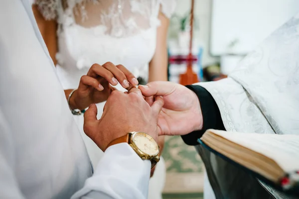 司祭は教会の花嫁と新郎の結婚指輪と手を祝福します — ストック写真