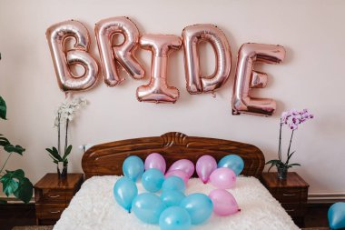 Yatak odasındaki yatakta pembe ve mavi balonlar. Gelinin düğün odasındaki dekoru..