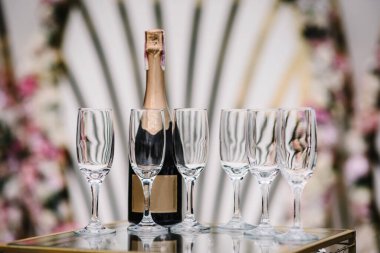 Altın arka planda şampanya kadehleri. Parti ve tatil kutlaması konsepti. Şampanya standı masanın üstünde..