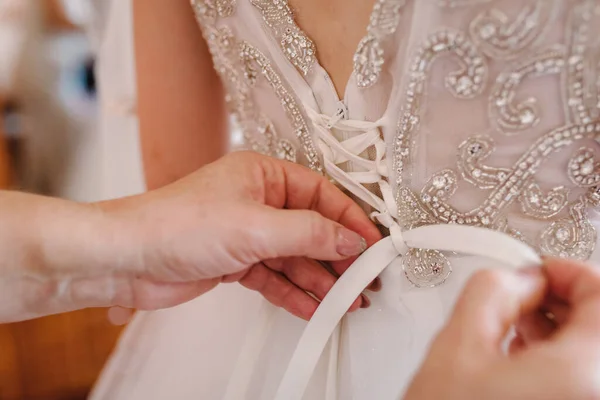 新婦付添人は 花嫁がコルセットを固定し 彼女のドレスを取得し 結婚式の日のために朝に花嫁を準備する — ストック写真