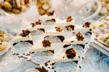 Parti için süslemeli pasta tabağı. Açık büfedeki lezzetli tatlılar. Muffinlerle dolu bir masa, düğün ziyafeti alanında bir parti için şekerlemeler. Kapatın. Çikolata. Düz yat. en üstteki görünüm.