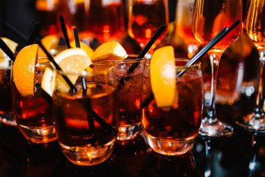 Bir sürü viski, viski, viski, bar masasında servis edilen buzlu brendi. Kaliteli şarap ve bir bardak burbon, konyak ve portakalla süslenmiş..