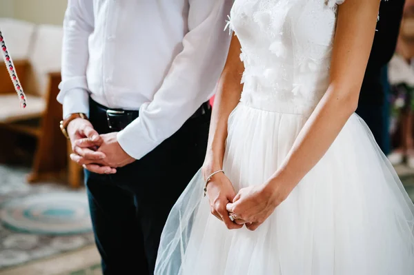 新娘和新郎在教堂举行的婚礼上交叉了手 手下留情 — 图库照片