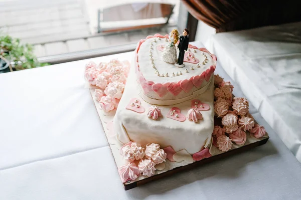 ペストリー付きのお祝いのテーブルの上にピンク色の白いウェディングケーキ ケーキを閉めろ 甘いテーブル — ストック写真