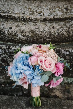 Çiçekli bir buket gül ve yeşil kurdeleli bir düğün. Düğün yüzükleri Gelin ve damat arka planda gelin buketinde.