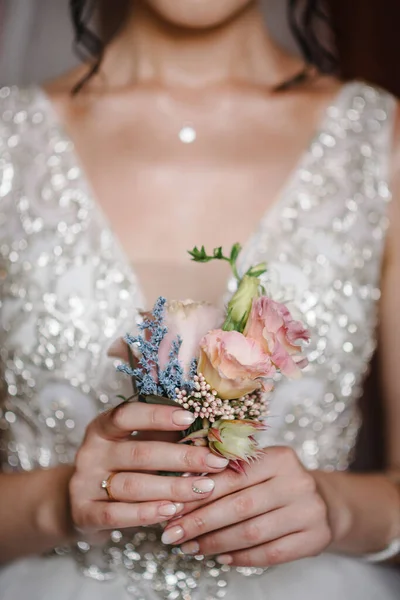 新娘手牵着新郎的纽扣孔 上面插着玫瑰 绿色和绿色的花朵 新娘的准备工作 婚礼早上的概念 — 图库照片