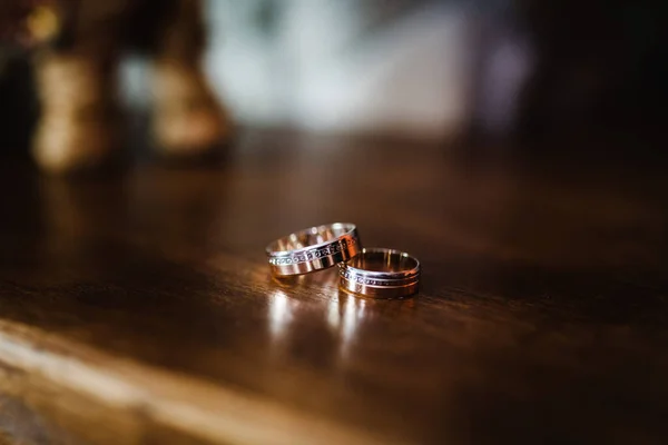 木製のテーブルの上に2つの結婚指輪 閉めろ サイドビュー — ストック写真