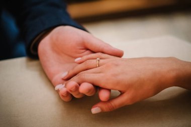 Nişan yüzüğü. Aşık bir adam kadın parmağına yüzük takıyor. Teklif et. Ellerinizi yakın tutun. Elinizi ve kalbinizi verin. Adam kadınına evlenme teklif ediyor. Sevgililer Günü akşamında nişanlı çift.